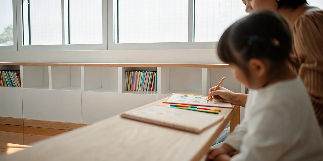Parent and child using grooved workbooks and magic pens for reading and spelling practice at a homeschool table