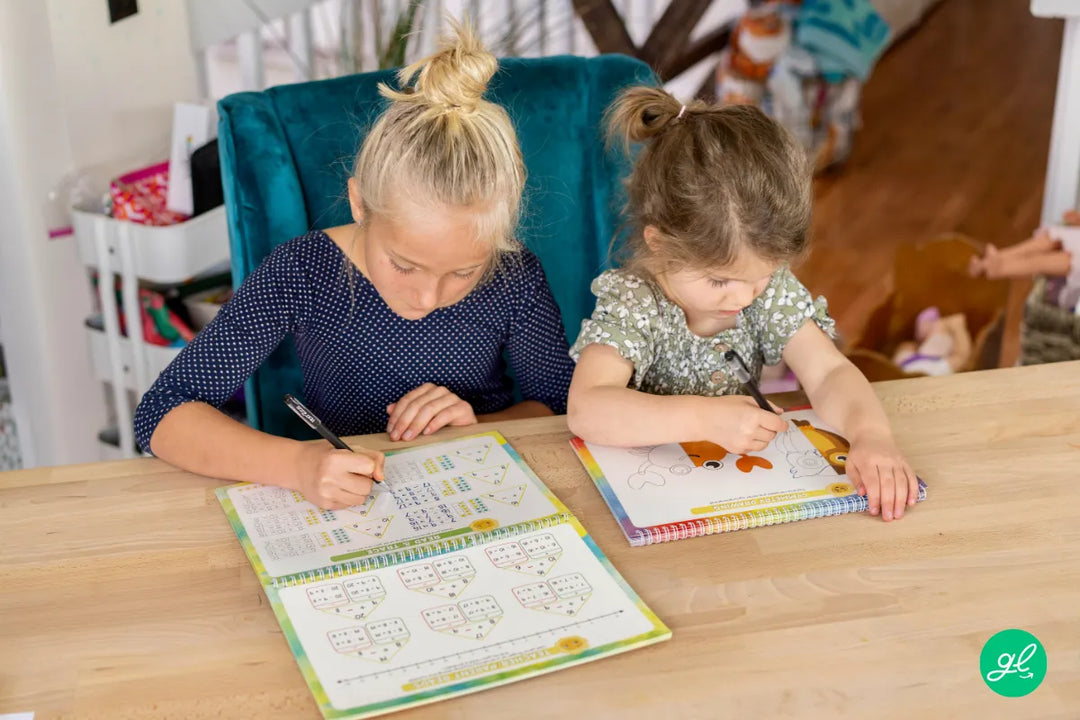 A child traces letters in a Spanish handwriting workbook for kids.